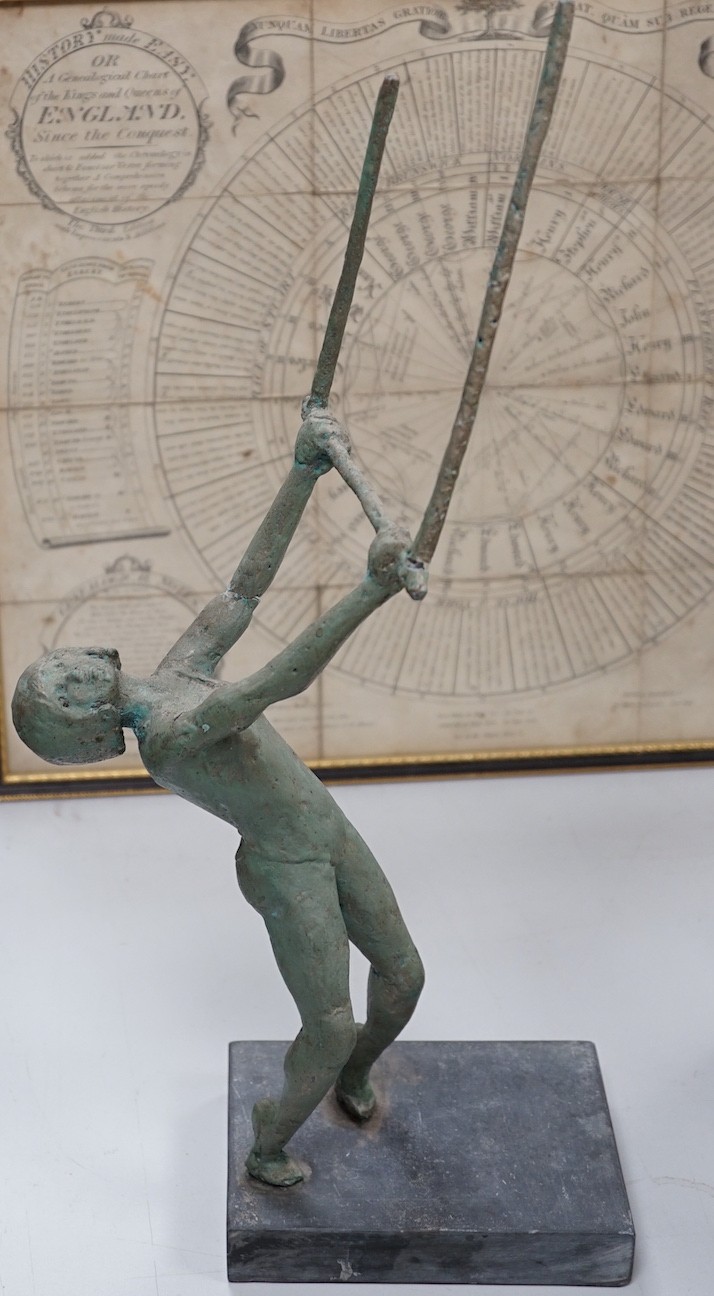 A maquette sculpture of a gymnast in pose swinging on a bar, 48cm tall